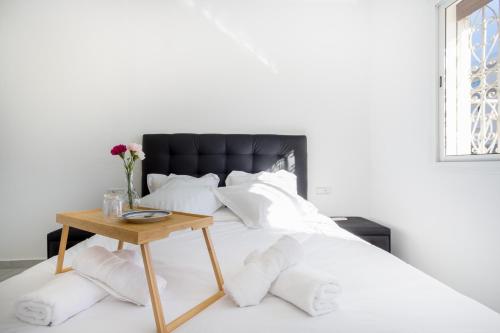a bed with a black headboard and a wooden table at Appartements Calmes et Spacieux in Tetouan