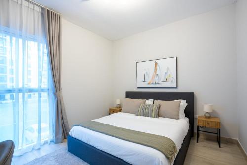 een slaapkamer met een bed en een groot raam bij 1 Bedroom Apartment Yas Island in Abu Dhabi
