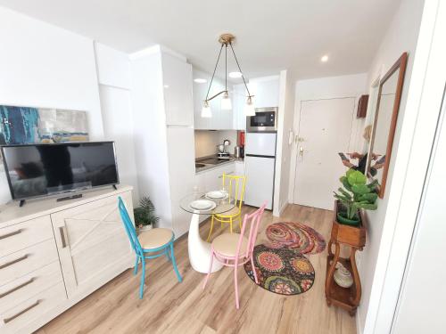 Una cocina con gabinetes blancos y una mesa y sillas. en Kyra House Centro Vigo, en Vigo