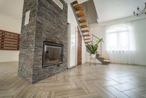 a large living room with a stone fireplace at RUNČI in Lautere