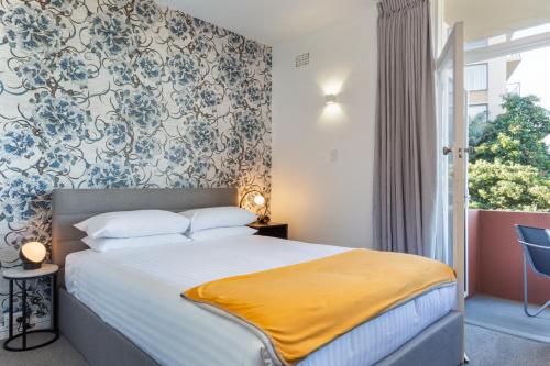 una camera con un letto con una coperta gialla di Comfy Balcony Studio near Parks, Shopping & Dining a Sydney
