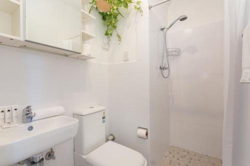 bagno bianco con servizi igienici e doccia di Comfy Balcony Studio near Parks, Shopping & Dining a Sydney