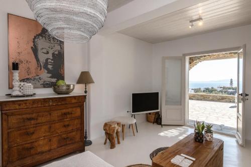 Enea by TinosHost في تينوس تاون: غرفة معيشة مع طاولة وتلفزيون