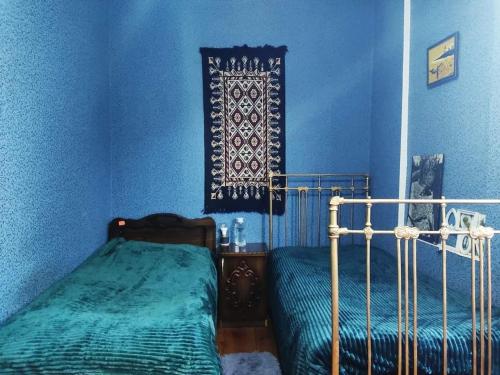 Vani的住宿－Grandmother Naziko，一间卧室设有一张床和蓝色的墙壁