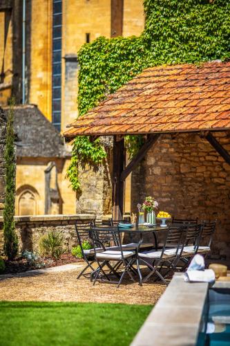 une table et des chaises assises sous un parasol dans l'établissement Maison des Chanoines, à Sarlat-la-Canéda