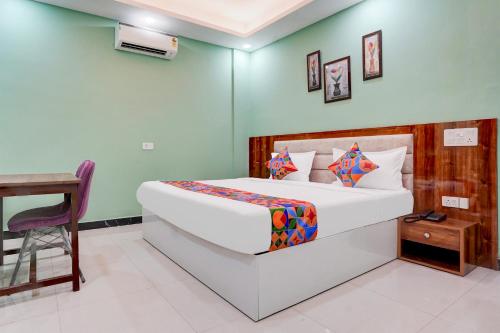 a bedroom with a bed and a table and a chair at FabHotel Sky - Nr Sapphire 83 Mall, Manesar in Gurgaon