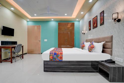 a bedroom with a bed and a desk in a room at FabHotel Sky - Nr Sapphire 83 Mall, Manesar in Gurgaon