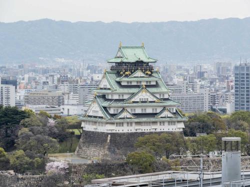 a large building with a tower on top of a city at The Rise Osaka Kitashinchi in Osaka