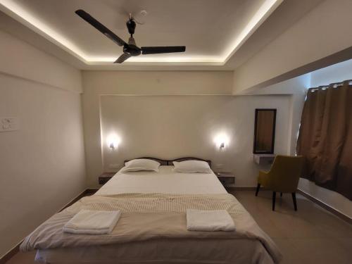 a bedroom with a large bed with a ceiling fan at Palm Crest The Colva Diaries in Colva