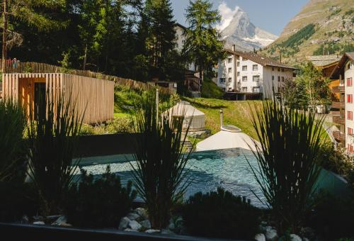 a swimming pool in a yard with a mountain in the background at Nomad by CERVO Mountain Resort in Zermatt