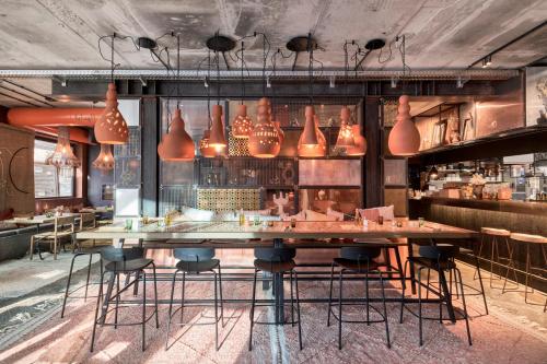 a restaurant with a large wooden table and chairs at Nomad by CERVO Mountain Resort in Zermatt
