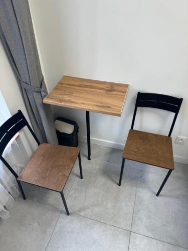 a table and two chairs in a room at Gray Hostel Katowice - Parking in Katowice