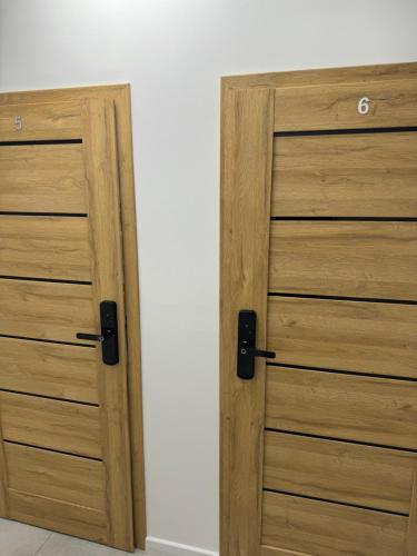 a pair of wooden doors in a room at Gray Hostel Katowice - Parking in Katowice