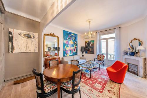 un salon avec une table et des chaises et une cheminée dans l'établissement L’app’Art Cannes - Contemporain Centre-Ville, à Cannes