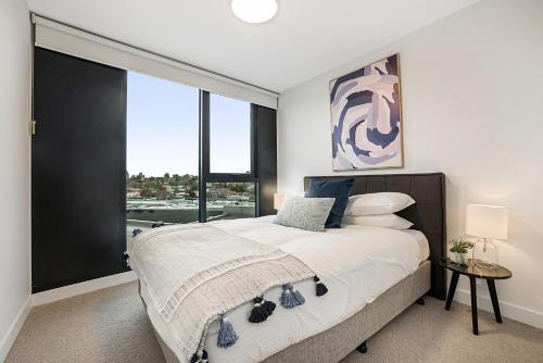 a bedroom with a large bed with a large window at Modern, Executive 1 Bedroom Apartment With Balcony in Melbourne