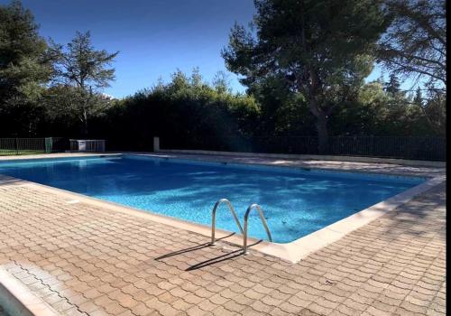 une piscine avec de l'eau bleue dans une cour dans l'établissement Beau studio coin nuit Centre Antibes, à Antibes