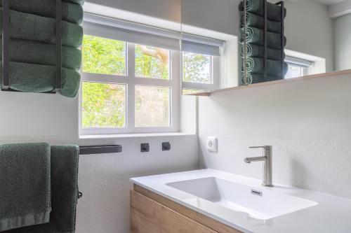 een badkamer met een wastafel en een raam bij PRIVÉ IN EEN BOSRIJKE OMGEVING Welkom bij gastenverblijf het ontsnapte schaap in Jubbega in Jubbega-Schurega