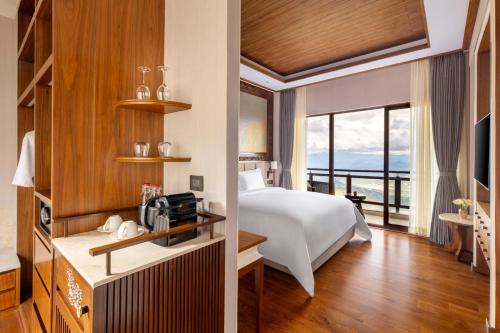 a hotel room with a bed and a balcony at Dusit Thani Himalayan Resort Dhulikhel, Nepal in Dhulikhel