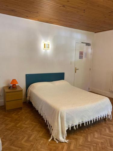 a bedroom with a bed with a blue headboard at Lods Hotel de France in Lods