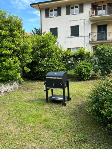a grill sitting in the grass in front of a building at CÀ GORLA BELLAGIO in Bellagio