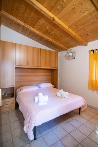 a bedroom with a large bed with two towels on it at Villaggio Camping Esca in Marina di Camerota