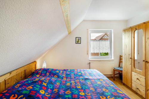 Schlafzimmer mit einem Bett und einem Fenster in der Unterkunft Ferienhaus Seestern in Krummhörn