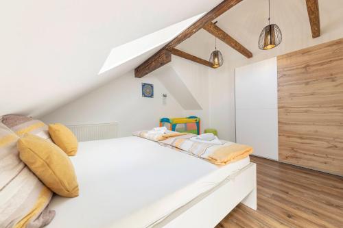 a bedroom with a white bed with yellow pillows at Holiday House Žalec 