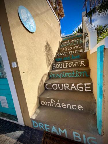 a staircase with a sign on the side of a building at CASA BOHO your happy place in Calheta in Calheta