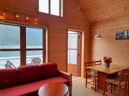 a living room with a red couch and a table at Vangsgaarden Gjestgiveri in Aurland