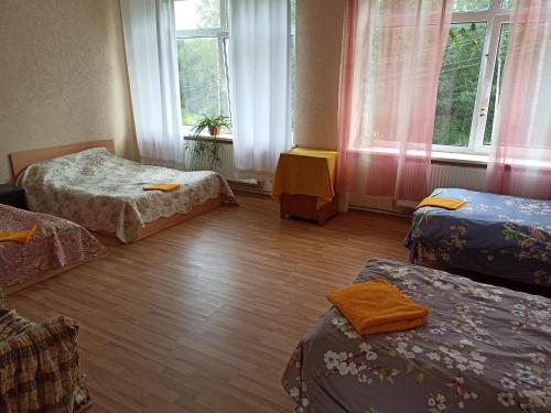 een kamer met 3 bedden en een raam bij VILLA ROZA Guest House in Rēzekne