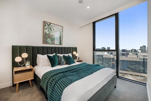 a bedroom with a large bed and a large window at Impeccably Styled 2-bedroom CBD Apartment in Melbourne