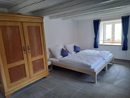 a bedroom with a bed and a wooden cabinet at Ferienwohnungen Heuboden und Wohnstüble in Hüfingen