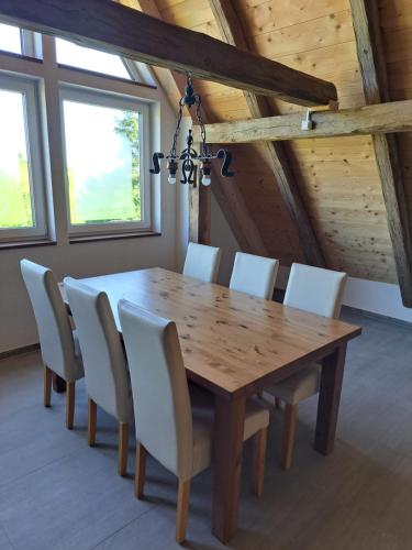 a dining room with a wooden table and chairs at Ferienwohnungen Heuboden und Wohnstüble in Hüfingen