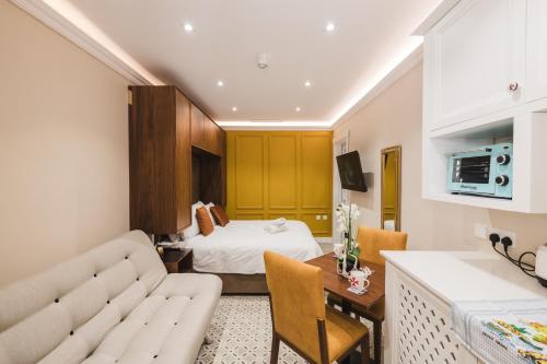 a hotel room with a couch and a bed at IŻ-ŻEBBUĠA BOUTIQUE SUITES in Żebbuġ