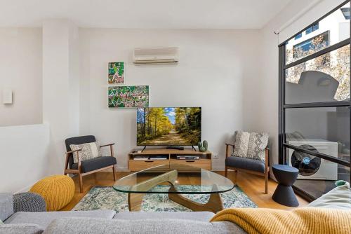 - un salon avec un canapé et une télévision dans l'établissement Beautiful 2-Storey Unit with Balcony near Smith St, à Melbourne