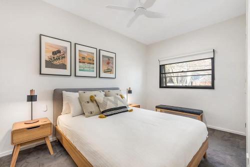 - une chambre avec un grand lit blanc et une fenêtre dans l'établissement Beautiful 2-Storey Unit with Balcony near Smith St, à Melbourne