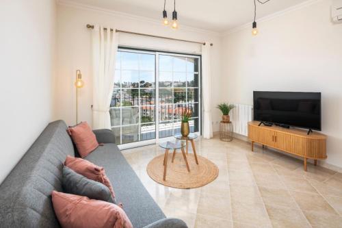 a living room with a couch and a flat screen tv at Casa Flandriana in Carvoeiro