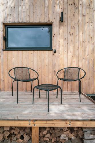 two chairs sitting on top of a wooden table at cozy Black Forest Tiny House close to lake in Schluchsee