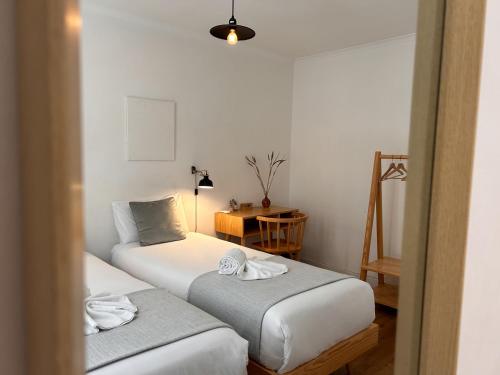 a room with two beds and a table with a lamp at 262 Baixa Guesthouse in Lisbon