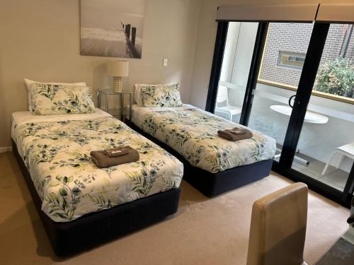 1 dormitorio con 2 camas y ventana en Kingston Foreshore-Kingsborough, en Kingston 