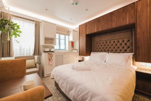 a bedroom with a large bed and a living room at IŻ-ŻEBBUĠA BOUTIQUE SUITES in Żebbuġ