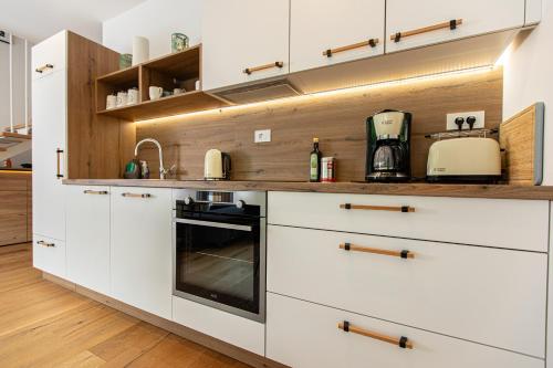 a kitchen with white cabinets and a stove at Apartma 21 - Ajda in Bovec