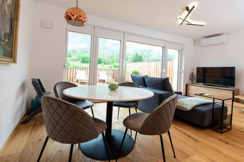 a living room with a table and chairs and a couch at Apartma 21 - Ajda in Bovec