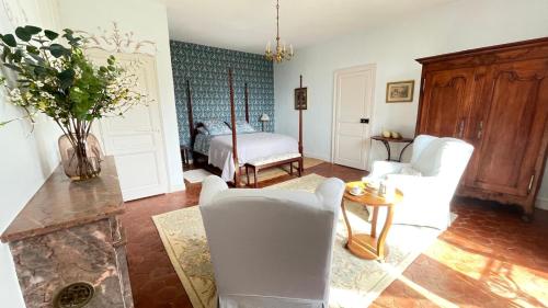 a living room with white chairs and a bed at Le Clos de Paris in Fresnay-sur-Sarthe