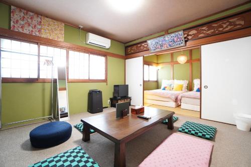 Pokój z pokojem z łóżkiem i stołem w obiekcie Sakurajima Parkside House B w Osace