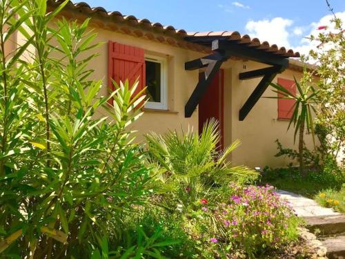 a house with a red door and some plants at Charmante petite maison vue panoramique et proximité mer in Saint-Raphaël