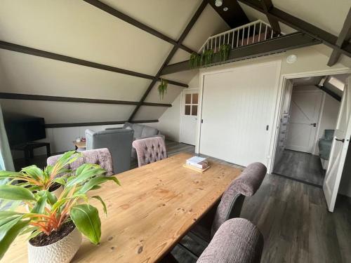 a wooden table and chairs in a room with a table at Logeren boven paarden in Jubbega-Schurega
