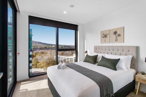1 dormitorio con cama grande y ventana grande en Central 2-Bed with Gym, BBQ & Stunning Views, en Canberra