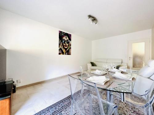 - un salon blanc avec une table et des chaises en verre dans l'établissement Cannes Center - Appartement 2 pièces avec terrasse, à Cannes