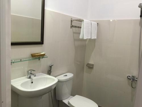 a white bathroom with a toilet and a sink at Tropical Garden Phu Quoc in Phú Quốc
